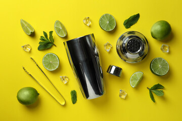 Cocktail shaker and ingredients for mojito on yellow background