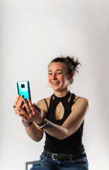 Alternative young woman with tattoos making a video call with her mobile phone.