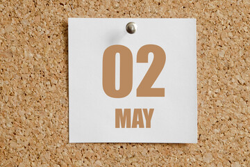 may 02. 02th day of the month, calendar date. White calendar sheet attached to brown cork board.Spring month, day of the year concept