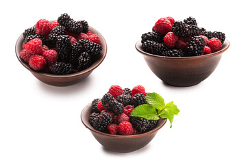 Raspberry, blackberry and mint leaf in ceramic brown bowl isolated on white