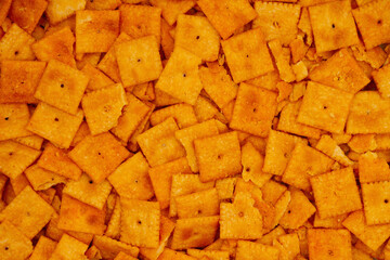 Cheese square crackers in pile background