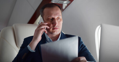 Successful businessman working in plane while enjoying first class flight