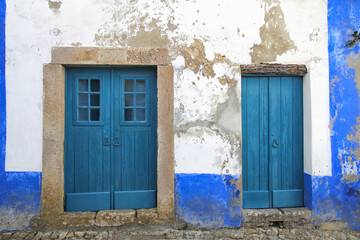 picturesque rustic blue doors in wall with peeling paint