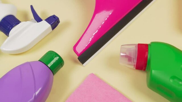 Flatley on objects of household chemicals, for restoring order in the house and washing windows on a pale yellow background. The concept of cleaning and chores around the house.