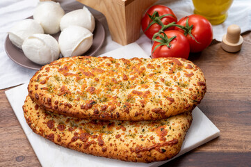 Tasty italian vegetarian food, fresh baked flat foccachia bread with white mozzarella cheese and...