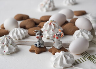 Easter festive background with eggs, cookies, marshmallows and bunny figurines. Place for your text.