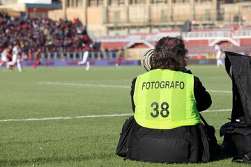 Fotografo sportivo in opera durante lo svolgimento di una partita di calcio