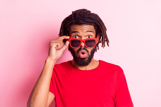 Photo of impressed funky dark skin man dressed red t-shirt arm hand eyeglasses big eyes isolated pink color background