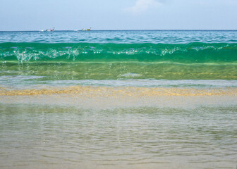 The sandy coast of the Andaman Sea in Thailand is washed by small waves. 