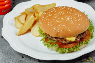 hamburger with fries and salad on the plate