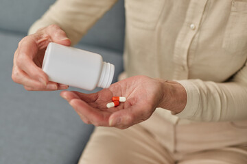 Senior woman taking daily medications at home during illness