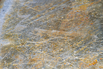 The surface of a kitchen frying pan covered with old burnt oil in soft focus under high magnification. Long-term used kitchen utensils.