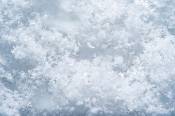 Background with close-up of snow under strong magnification. Slightly melted snow with sharp edges in soft focus.