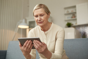 Senior woman using digital tablet at home. The use of technology by the elderly.