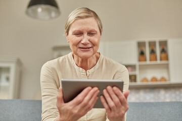 Senior woman using digital tablet at home. The use of technology by the elderly.