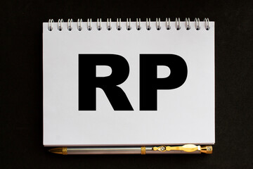 text RP in notepad. office furniture on the table. business and finance