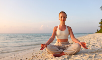 Fototapeta na wymiar Peaceful woman meditating in Padmasana on coast