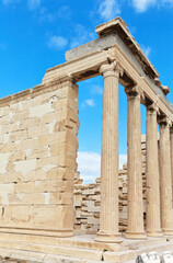 Fototapeta premium Greece. Athens. Ionian portico of Erechtheion temple on ancient Acropolis (421-406 BC) with a colonnade on the eastern facade against a blue sky with clouds. Travel and excursions to historical sites
