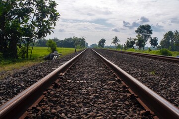 Train tracks on the natural gravel with cloudy sky