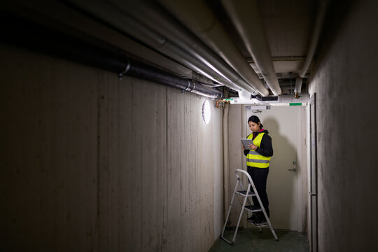 Female plumber checking pipes