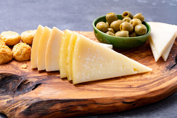 Spanish snacks tapas, variety of sliced goat, sheep, manchego cheeses, green olives