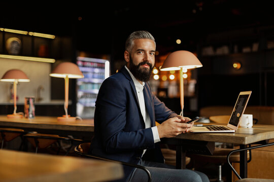 Businessman in cafe looking at camera