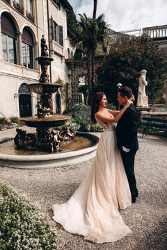 Walk of the newlyweds at the fountain against the backdrop of the old mansion. Summer sunny day.