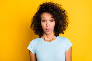 Photo of charming impressed dark skin wavy lady wear blue t-shirt big eyes isolated yellow color background