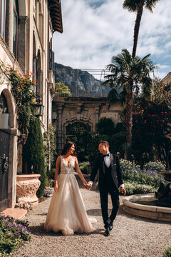 Walk of the newlyweds at the fountain against the backdrop of the old mansion. Summer sunny day.