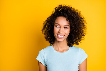 Photo portrait of dreamy afro american woman looking at blank space isolated on vivid yellow colored background