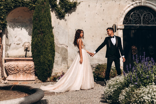 Walk of the newlyweds at the fountain against the backdrop of the old mansion. Summer sunny day.