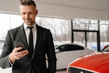Mid aged businessman holding mobile phone