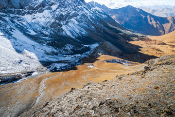 mountain landscape in Juta trekking area landscape with snowy mountains in sunny autumn day - popular hiking in the Caucasus mountains, Kazbegi region, Georgia.