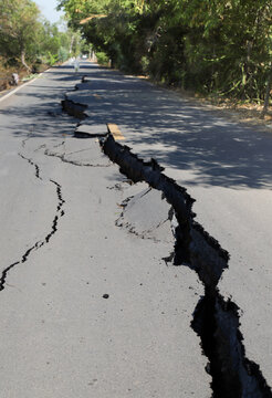 Asphalt road collapsed with cracks. Vertical view. 