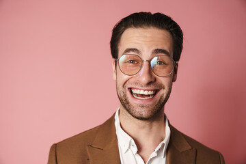 Unshaven white man in eyeglasses looking and laughing at camera