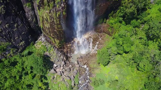 Diyaluma falls with colorful rainbow on high steep cliff