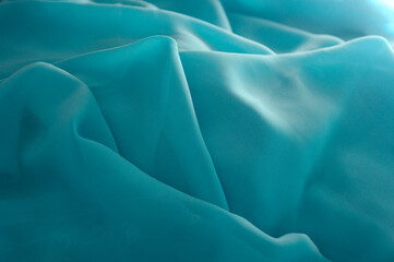 turquoise green flowing fabric background texture with copy space