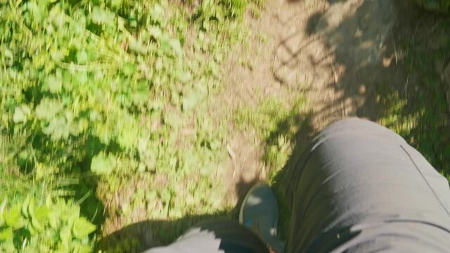 Up view of legs in sportshoes walking on bridge hanging over the river Mahar with strong flow.
