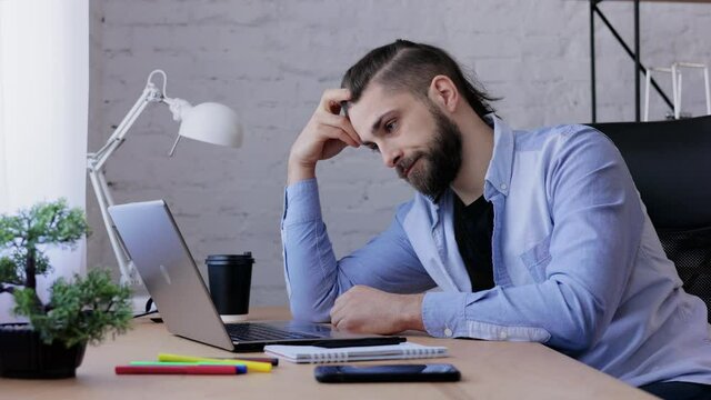 Depressed man overworked on laptop computer. Stressed worker recieved bad online news, failed exam results, had lack of creative ideas. Burnout syndrome, overworking, depression, apathy.