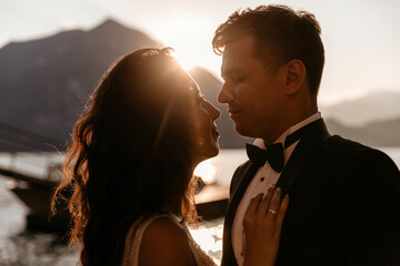 Evening walk of the newlyweds on the shore of the lake. Photoshoot at sunset.