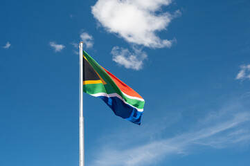 Waving South African flag against blue sky