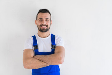 Bearded handyman in overalls posing on camera