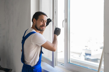 Handyman installs the window and looks at the camera