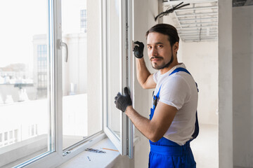 The foreman stands at the open window and smiling