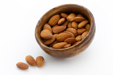 bamboo bowl of almonds on white background
