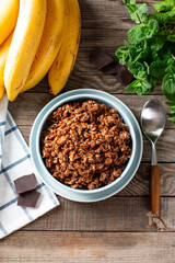 Chocolate oatmeal porridge with banana in bowl, decorated mint. Top view