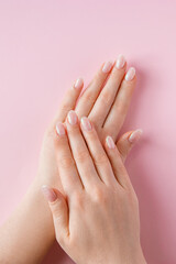 Skin care concept. Beautiful female hands on pink background. Place for text.