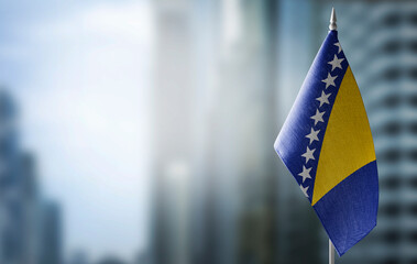 A small flag of Bosnia and Herzegovina on the background of a blurred background