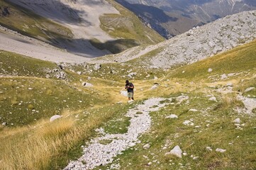 An isolated man is hiking in the mountains of the Monti Sibillini National Park (Marche, Italy, Europe)