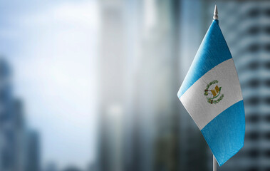 A small flag of Guatemala on the background of a blurred background
